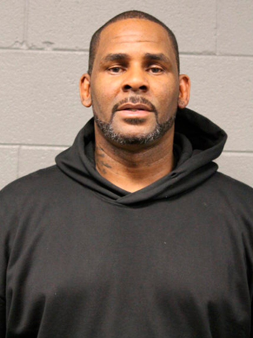 A man looks at the camera as a police mugshot is taken