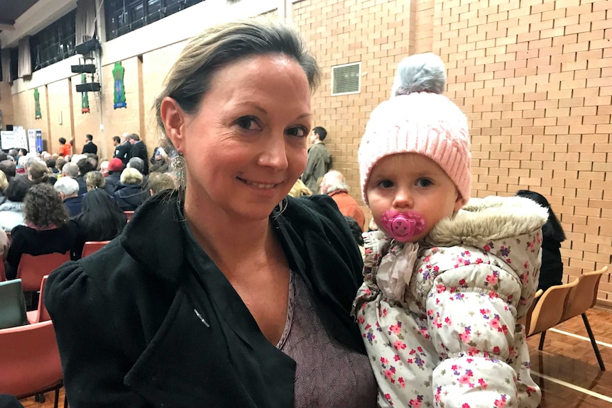 A mother and baby at a forum.