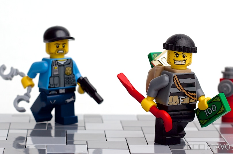 A Lego policeman chases a Lego robber.