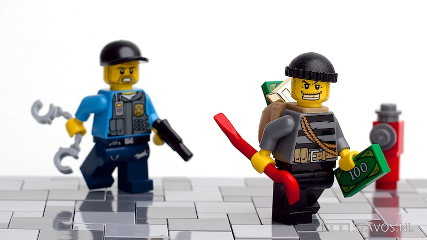 A Lego policeman chases a Lego robber.