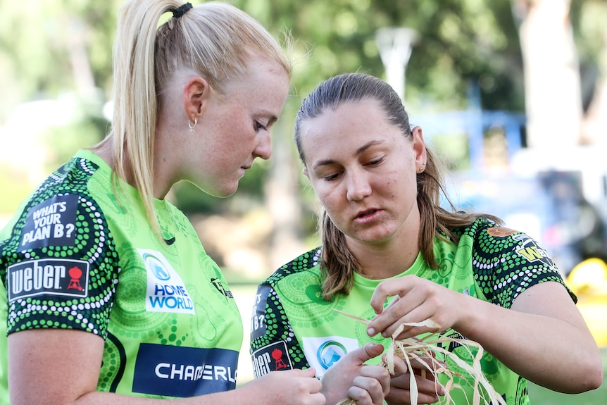 Two women try basket weaving