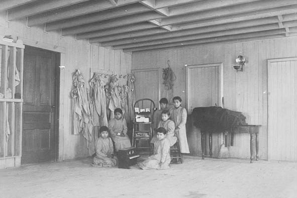 Six students posed in a room at a Native American boarding school.