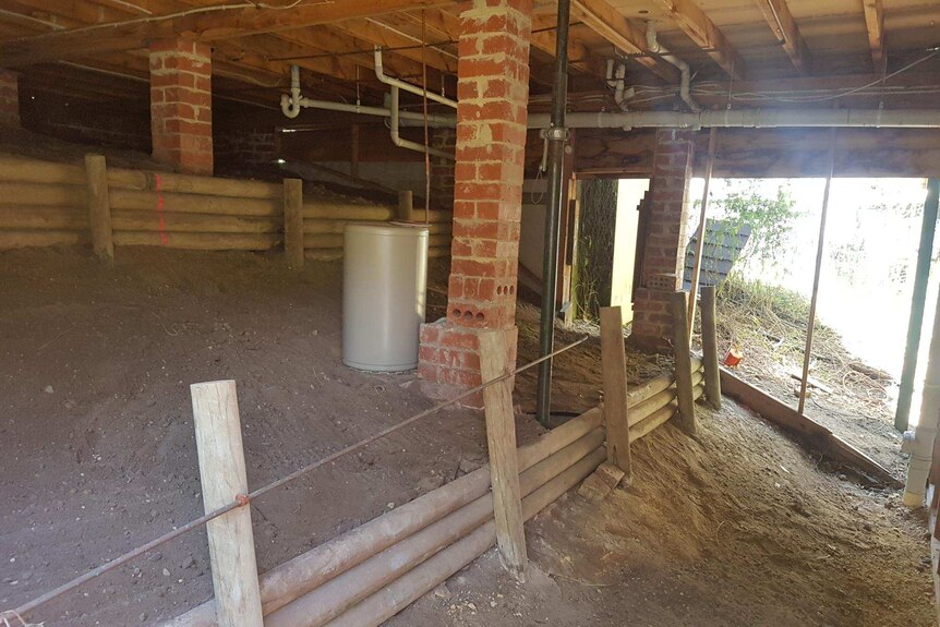 Underneath a Blue Mountains home, including a dirt area and piping