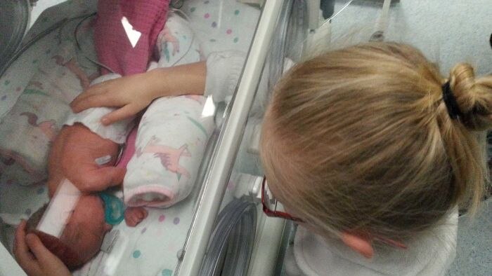 Peyton Drinkwater (berusia 6) menyentuh adik bayinya Paige 2018.