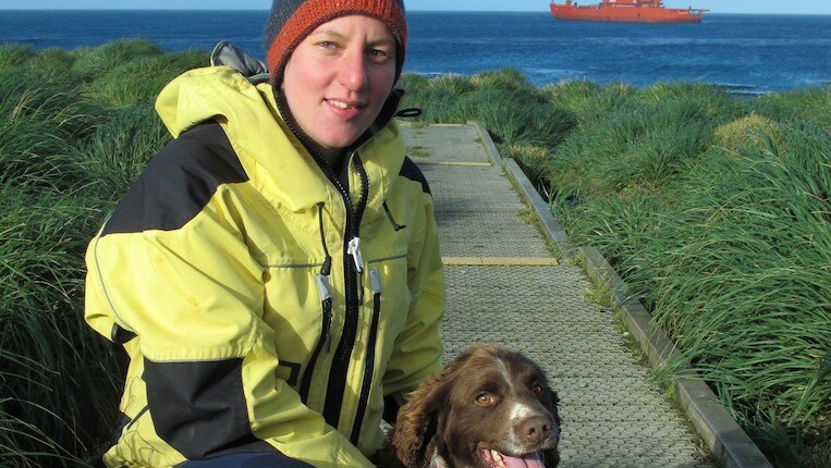 Rabbit hunter Darna Boyte and dog Joker on Macquarie Island with Aurora Australis in the background.