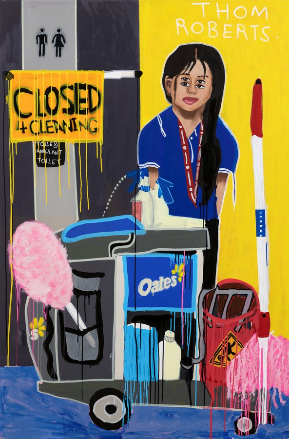 Painting on cleaner Subita, standing with her cleaning trolley next to a yellow wall. she has long dark hair and a blue tshirt 