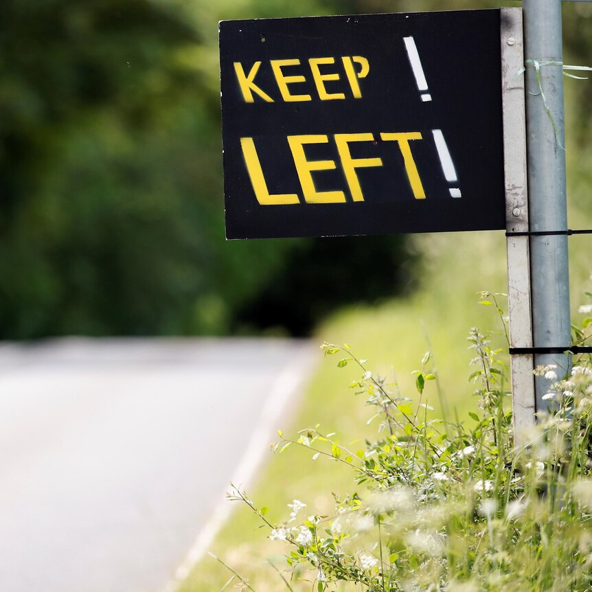 A sign by the road side reads KEEP! LEFT!