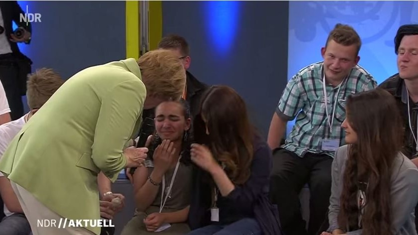 Angela Merkel comforts a crying Palestinian refugee