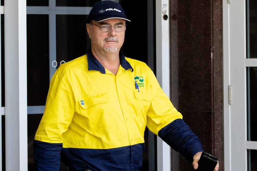 A man who appears to be in his 50s wears hi-vis as he exits court.