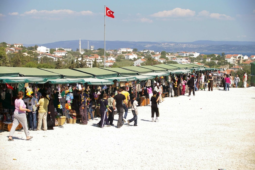 Long row of market stalls with Turkish flag flying above