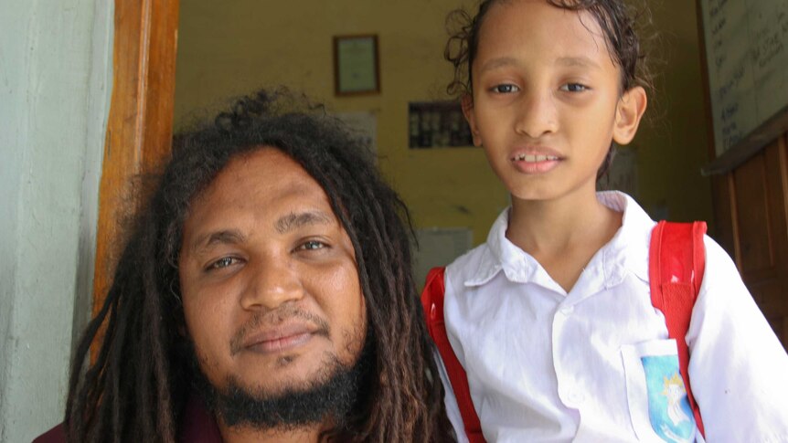 Juvinal Dias from the Timor-Leste organisation La’o Hamutuk, sitting beside his young daughter Paya.