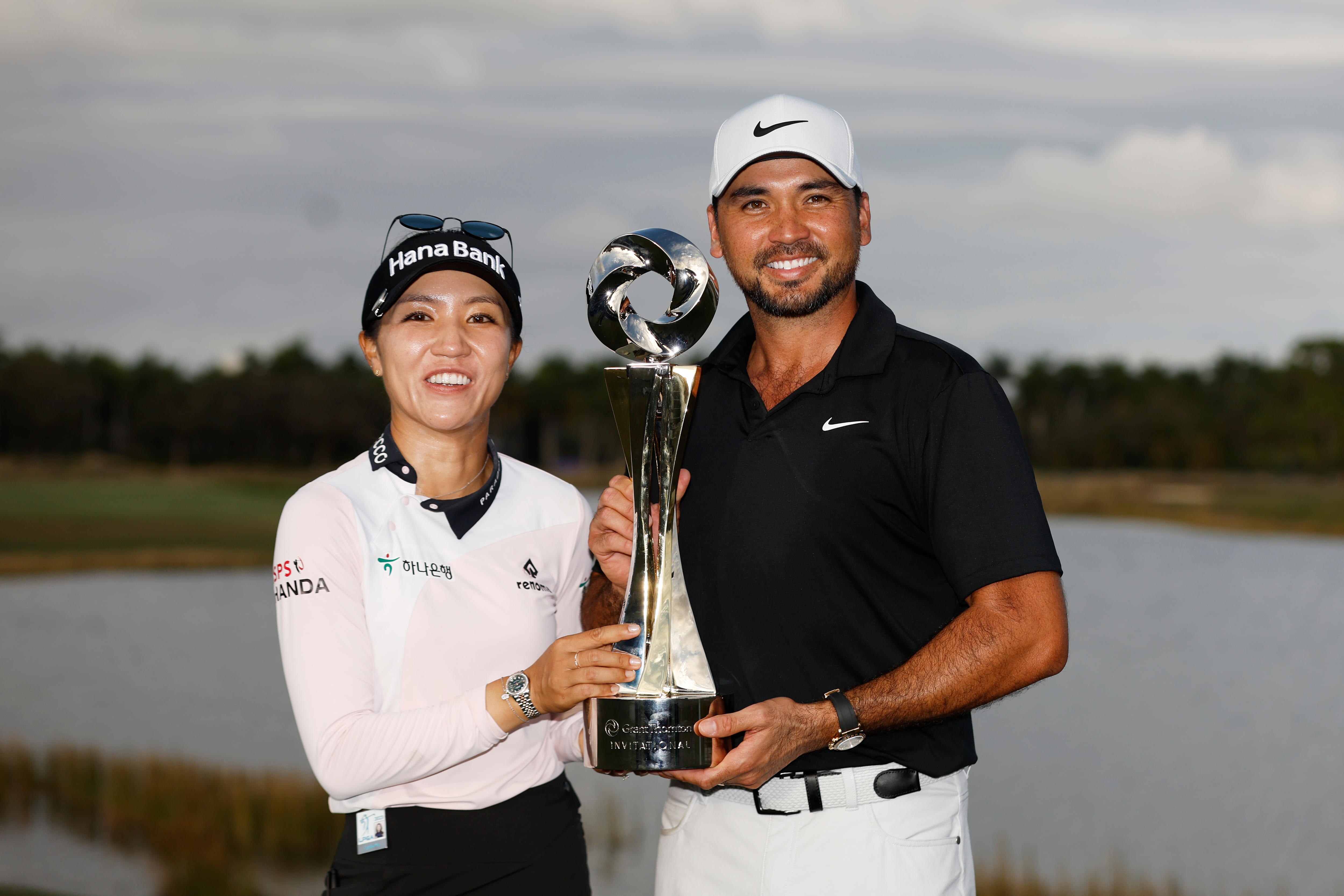 Lydia Ko and Jason Day celebrate with a trophy after winning a mixed teams event.