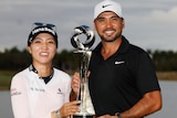 Lydia Ko and Jason Day celebrate with a trophy after winning a mixed teams event.