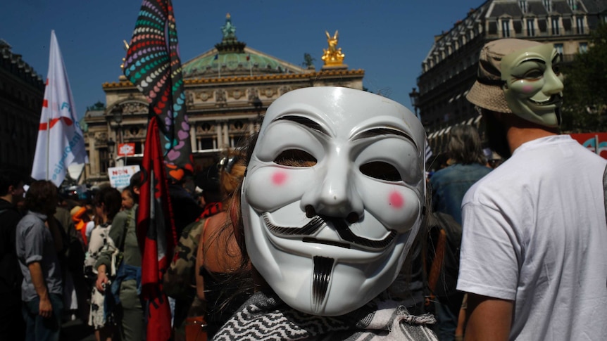 Protesters wearing Guy Fawkes masks attend a protest in Paris, France, Saturday, May 5, 2018.