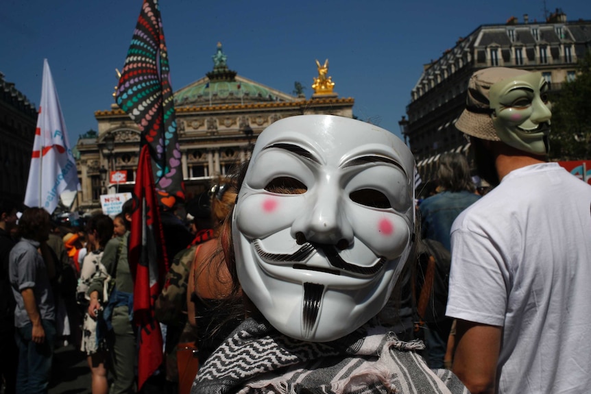Protesters wearing Guy Fawkes masks attend a protest in Paris, France, Saturday, May 5, 2018.