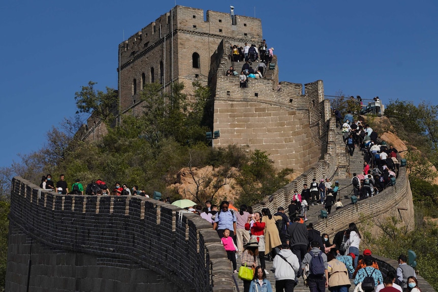 Tourists climb up a stretch of the Badaling Great Wall of China on the outskirts of Beijing