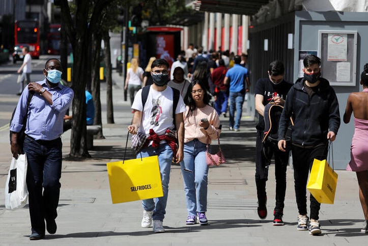 Pedestrians carry shopping bags in London amid the coronavirus outbreak.