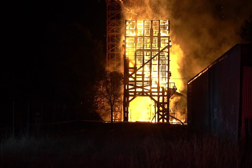 A fire consumes a large timber structure.