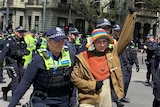 A police officer leads a climate change protester away after being arrested in Melbourne.