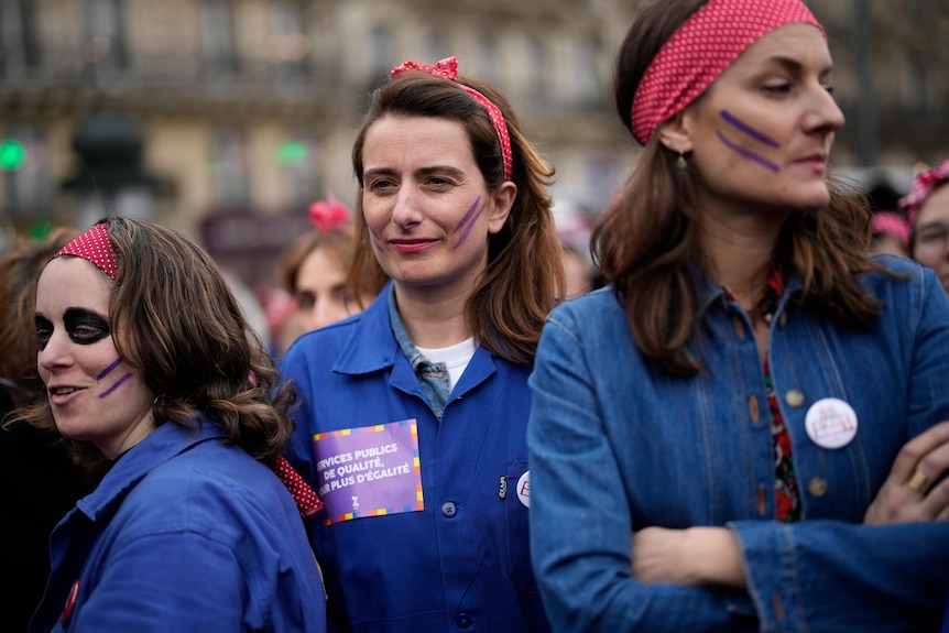 Women dress in workers uniforms during a rally in France.