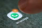 The WhatsApp app logo is seen on a smartphone.