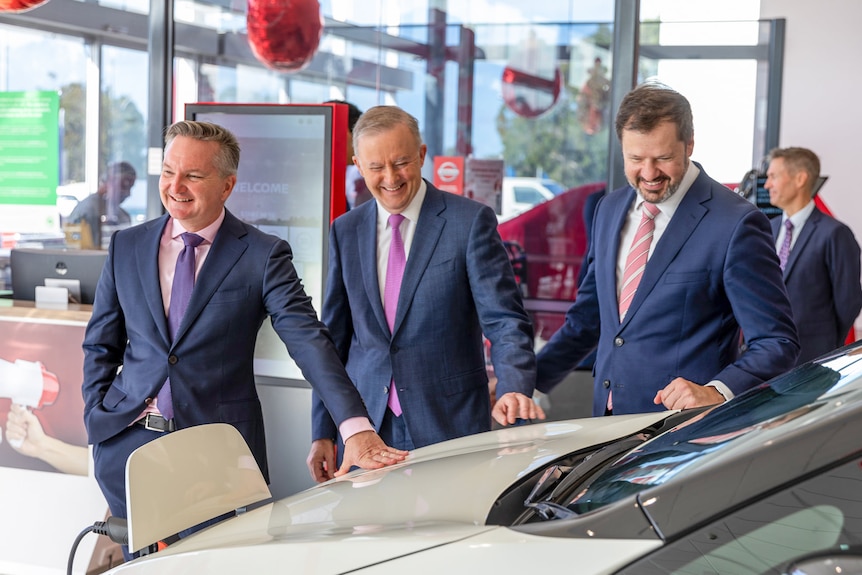 Labor's environmental spokesman Chris Bowen, Anthony Albanese and Labor MP Ed Husic check out a Nissan Leaf inside a showroom.