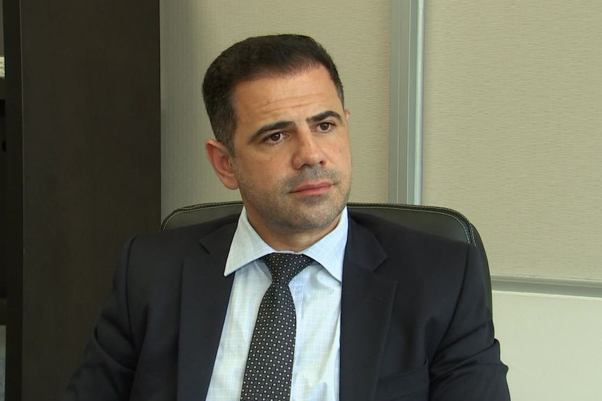 A man in a suit sitting in an office chair