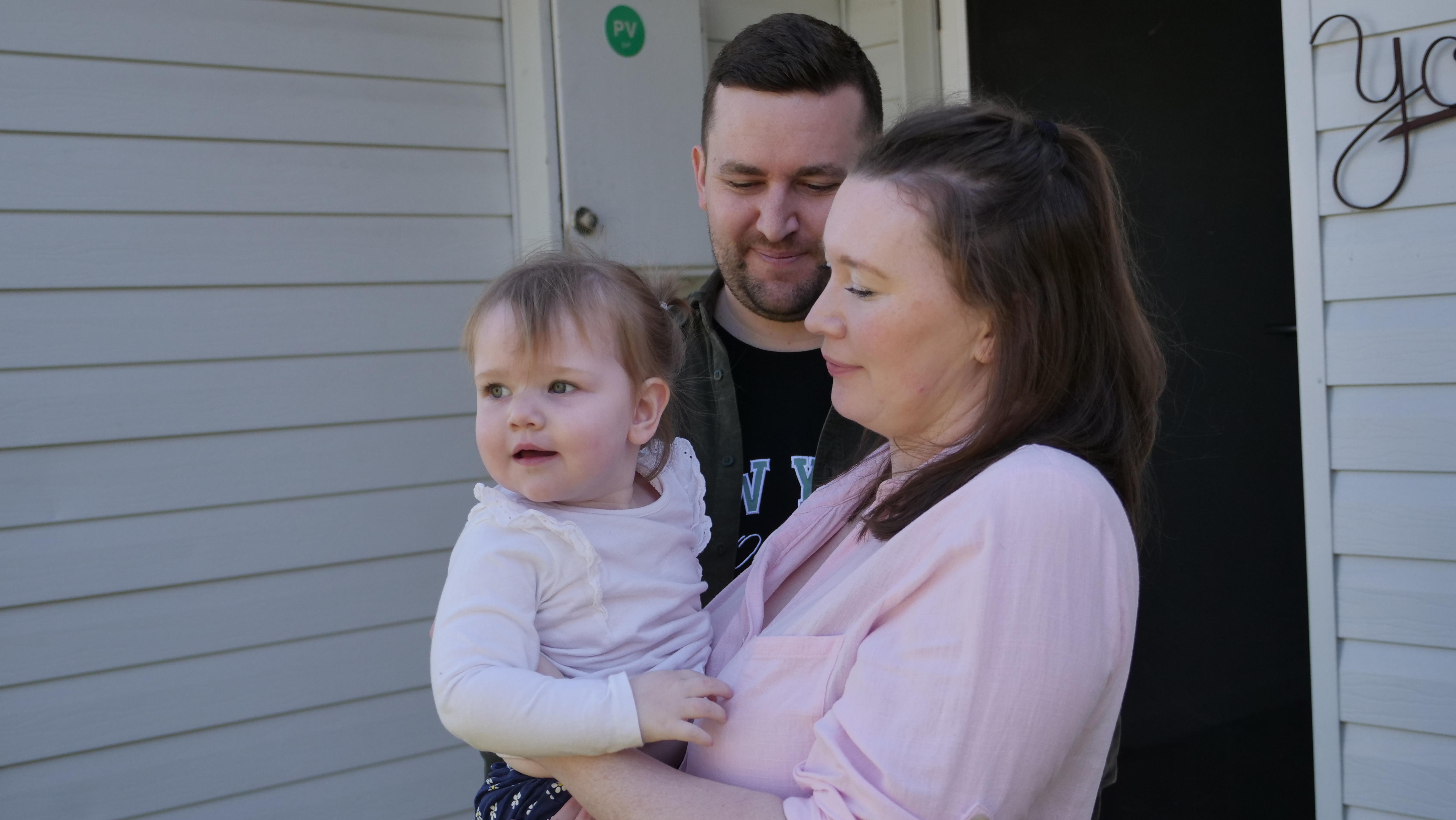 Megan and Brandon Raines look lovingly at their toddler daughter Daisy. 