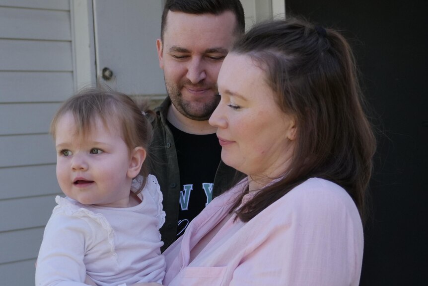 Megan and Brandon Raines look lovingly at their toddler daughter Daisy. 