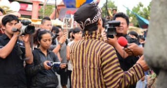 A man facing cameras and reporters