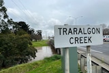 Traralgon Creek sign on bridge of flooded creek