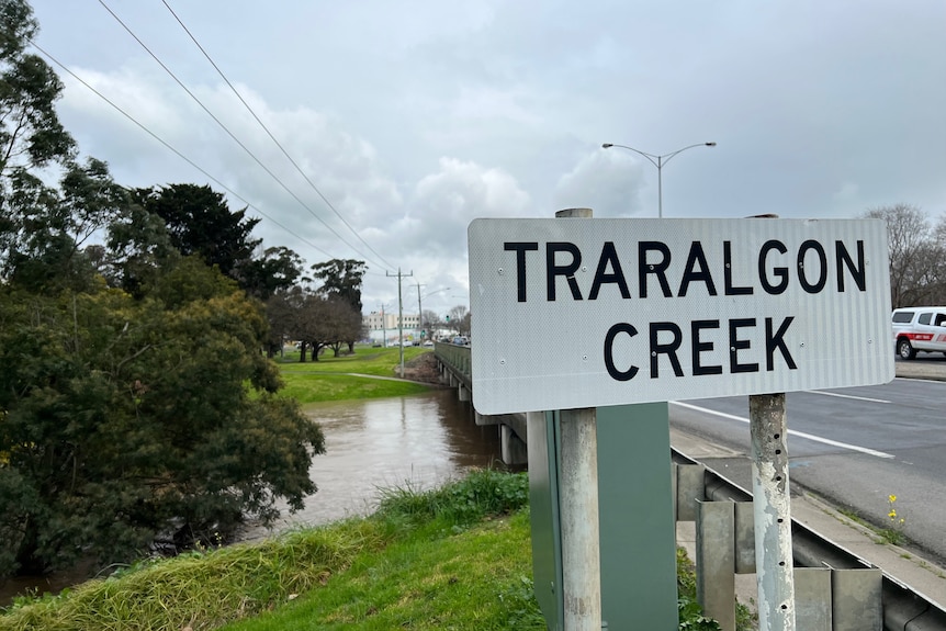 Traralgon Creek sign on bridge of flooded creek