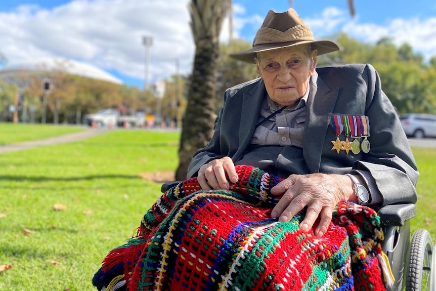 A veteran in a wheelchair with his medals.