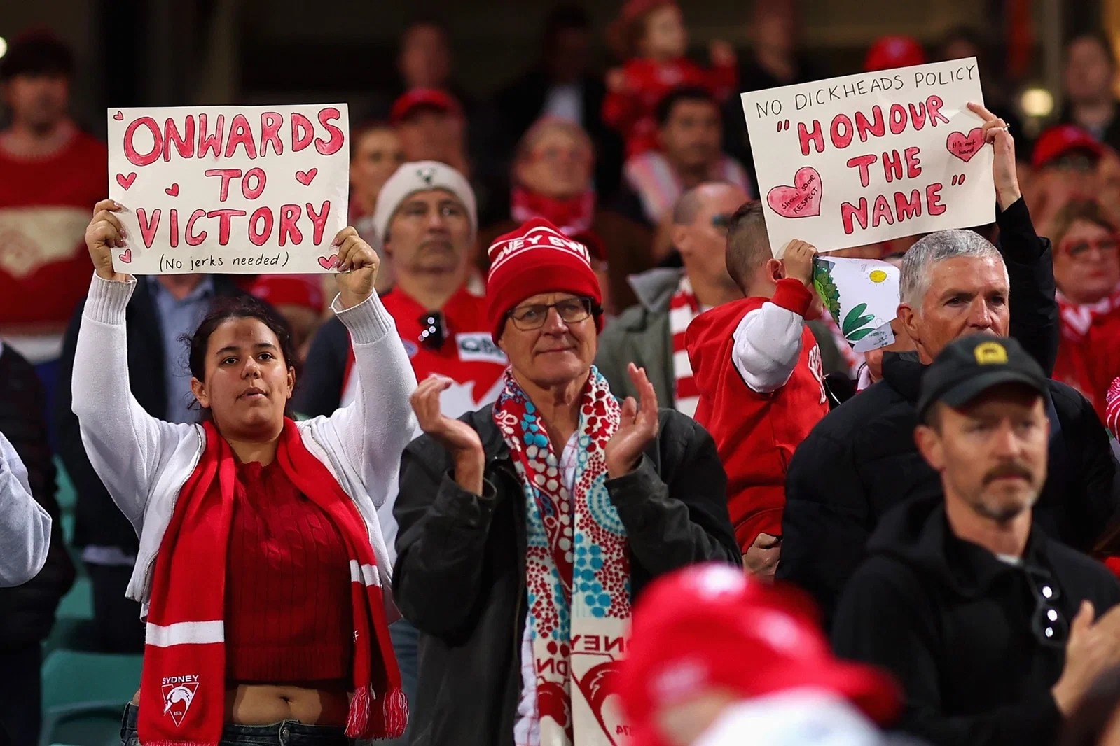 Swans fans show their support, standing, applauding and holding signs