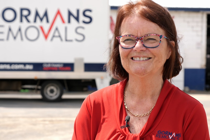 Jacque Gorman smiling, Gormans Removals truck in the background. 