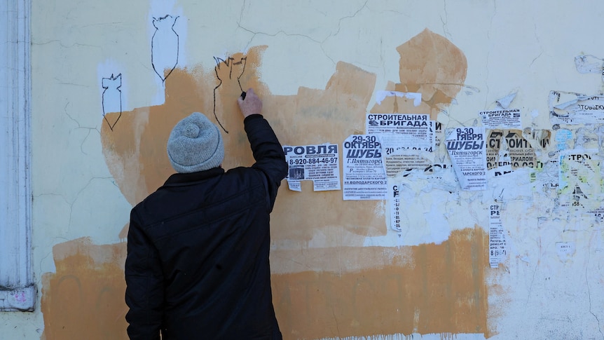 A man drawing on a wall
