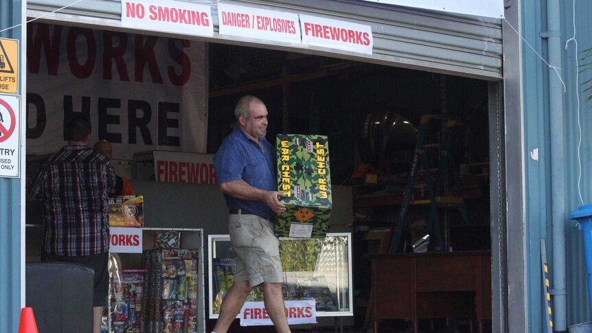 A man holding a box of fireworks.