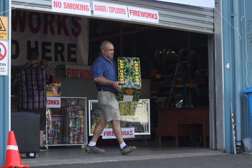 A man holding a box of fireworks.