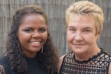 A young Indigenous woman and a middle-aged non-Indigenous woman smile at the camera.