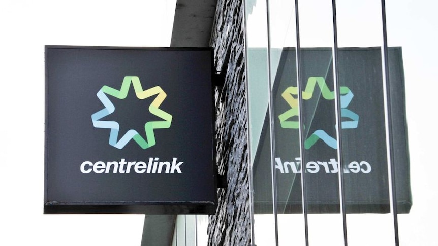 A sign of Centrelink mirrored in a window.