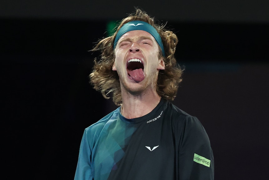 Andrey Rublev sticks his tongue out during an Australian Open match.