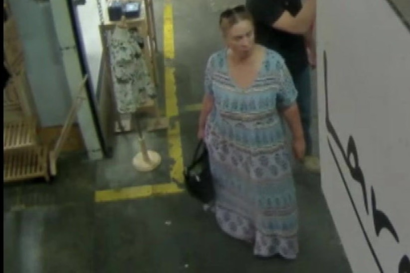 A still from CCTV footage of a woman in a shop.