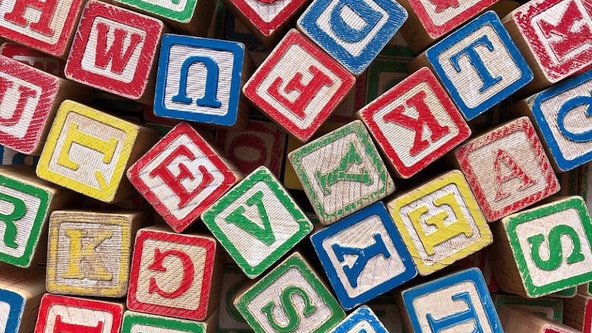 Photo of childrens blocks with letters on them in red, green, yellow and blue 