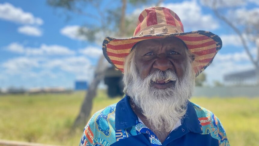 An Aboriginal man smiles at a camera outdoors