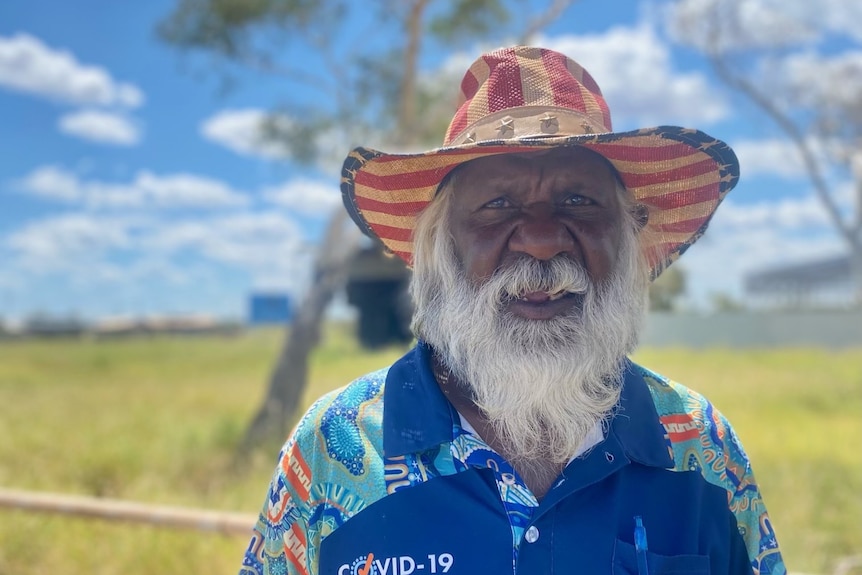An Aboriginal man smiles at a camera outdoors