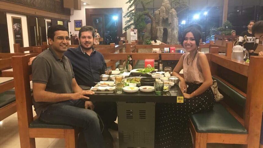 Cambodian opposition leader Kem Sokha's daughter sits at a dinner table with American journalist Geoffrey Cain and one other man