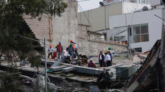 Rescuers work among rubble from a collapsed building.