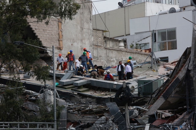 Rescuers work among rubble from a collapsed building.