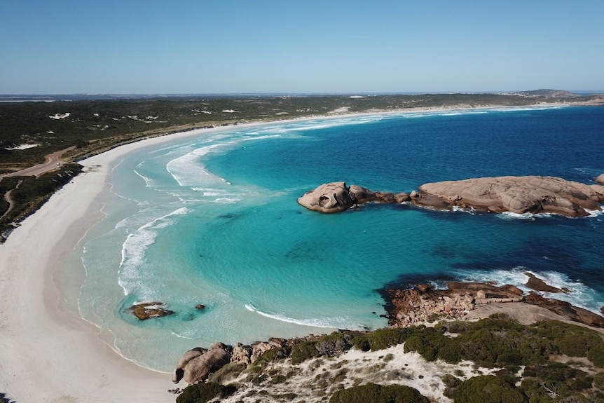 Photo of an Esperance beach with blue water and rocks