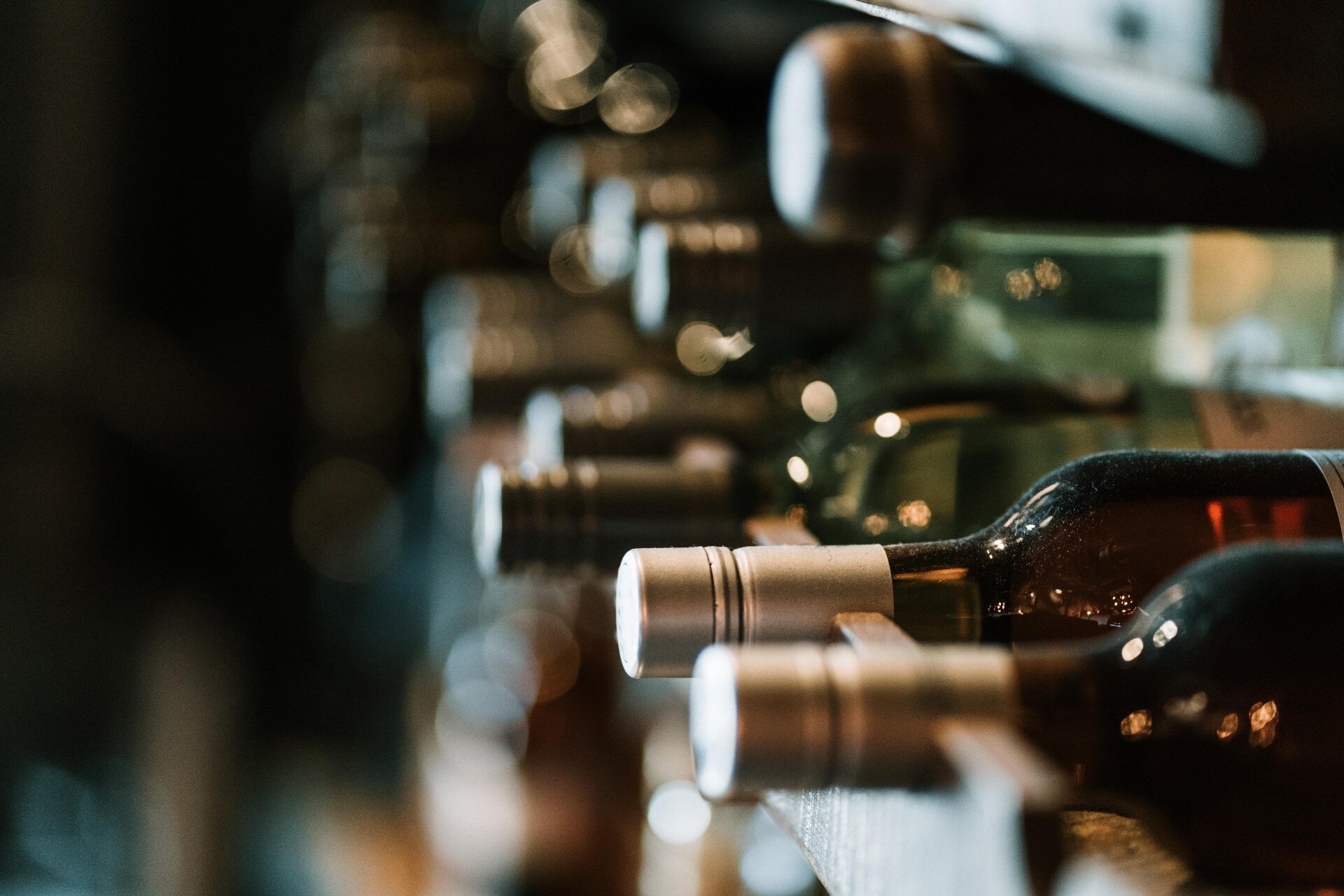 A close up of wine bottles on a shelf in a bottle shop.